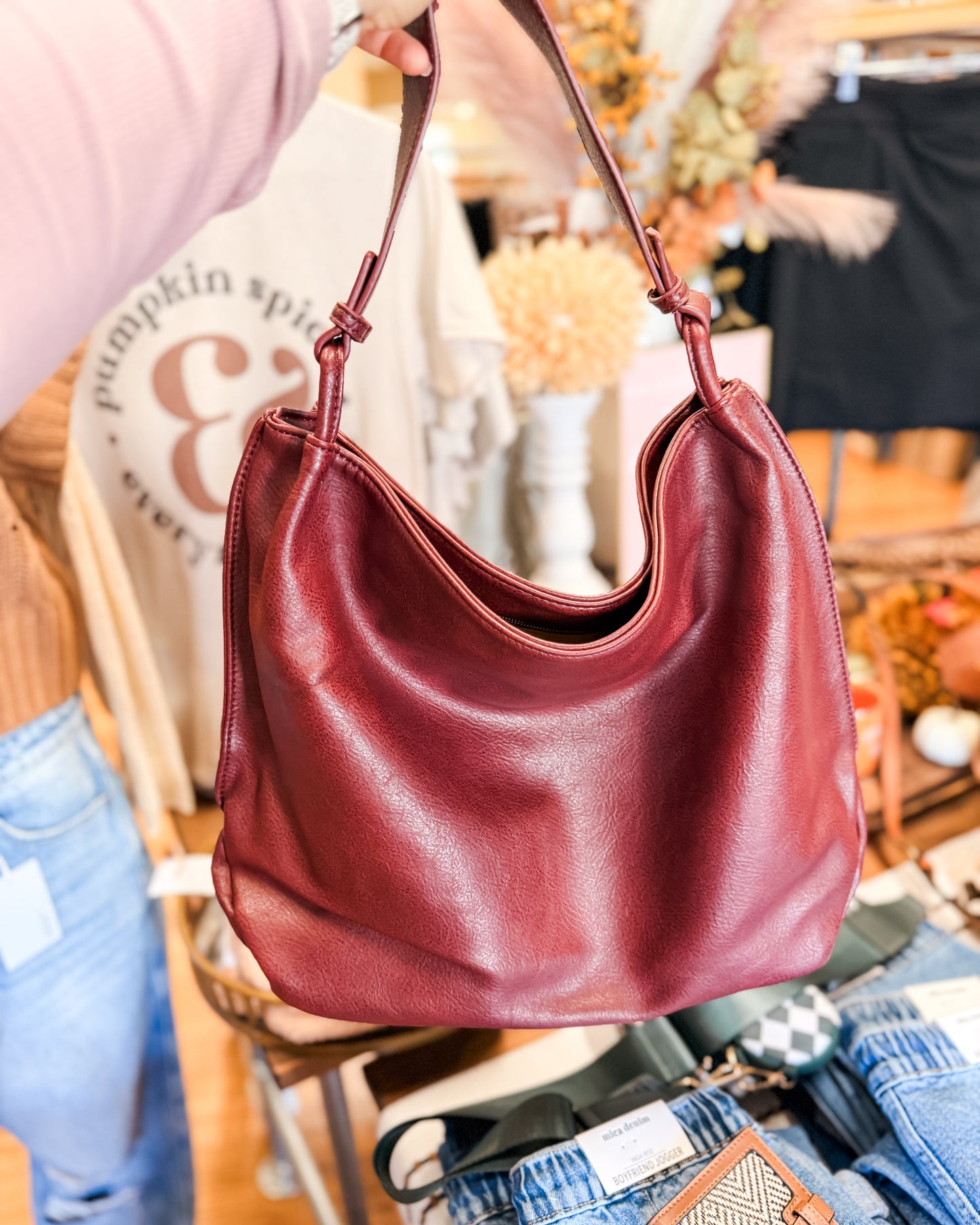 Red handbag held by a person with a blurred background