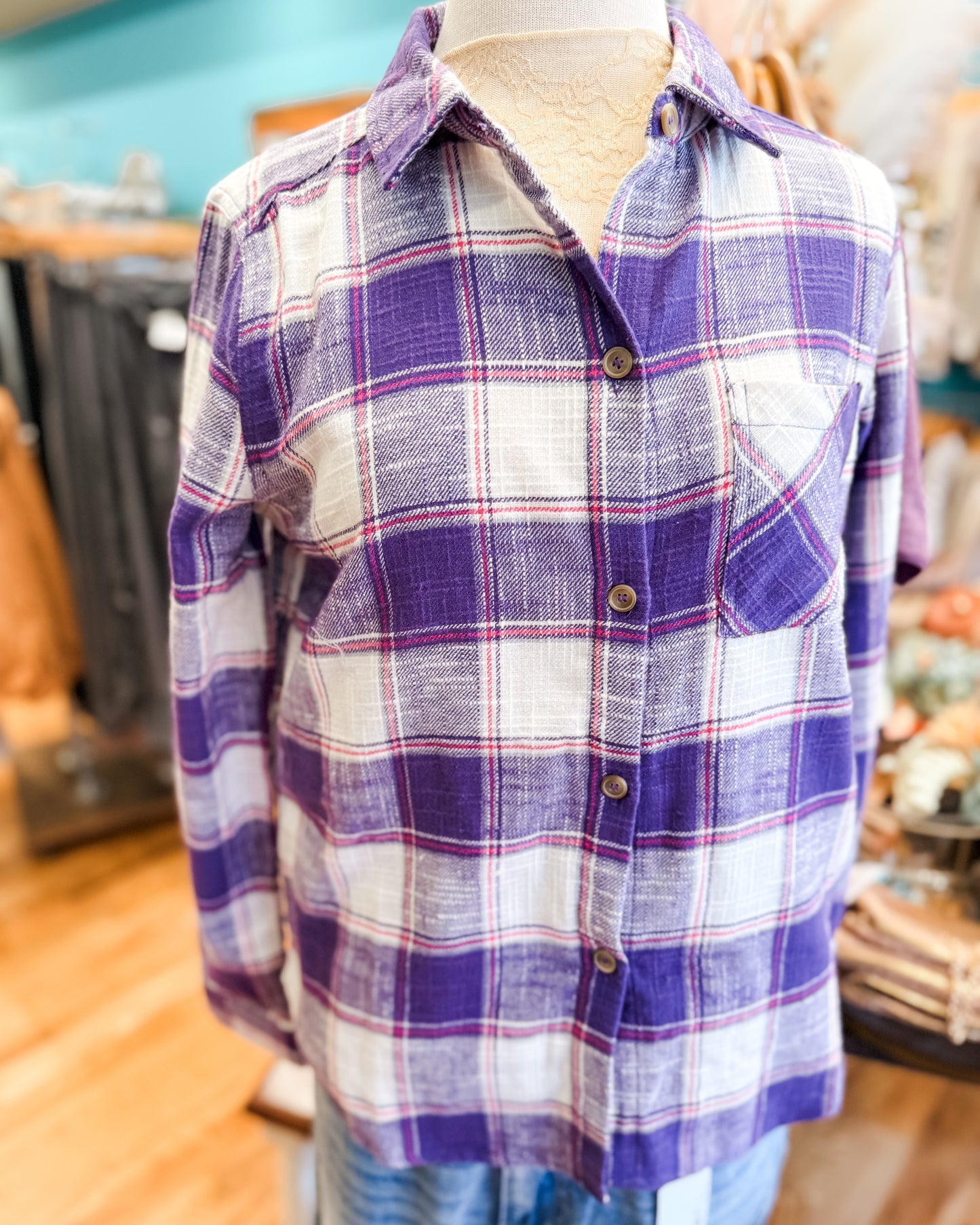 Purple and white plaid shirt on a mannequin in a store setting