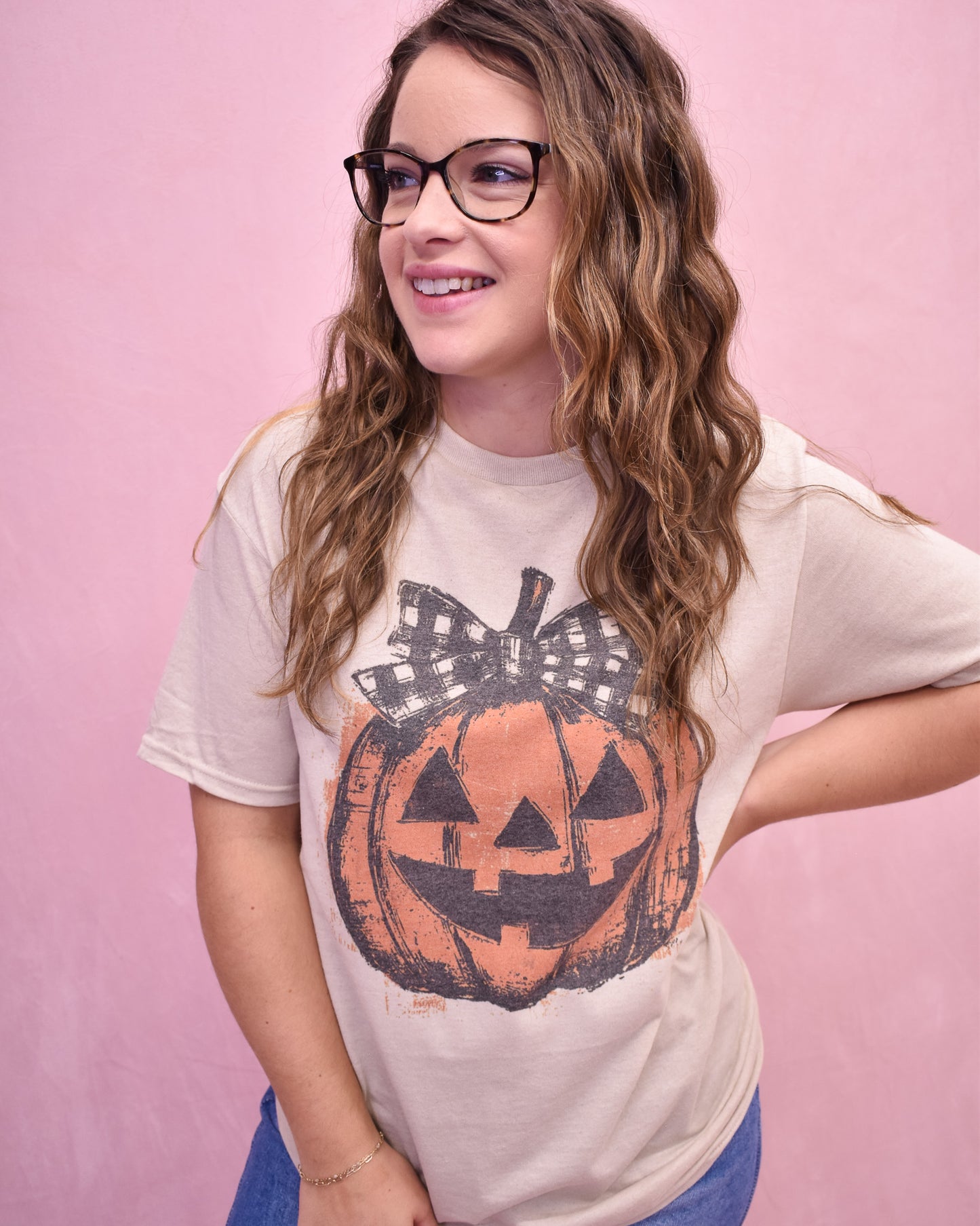 Woman wearing a t-shirt with a pumpkin design on a pink background