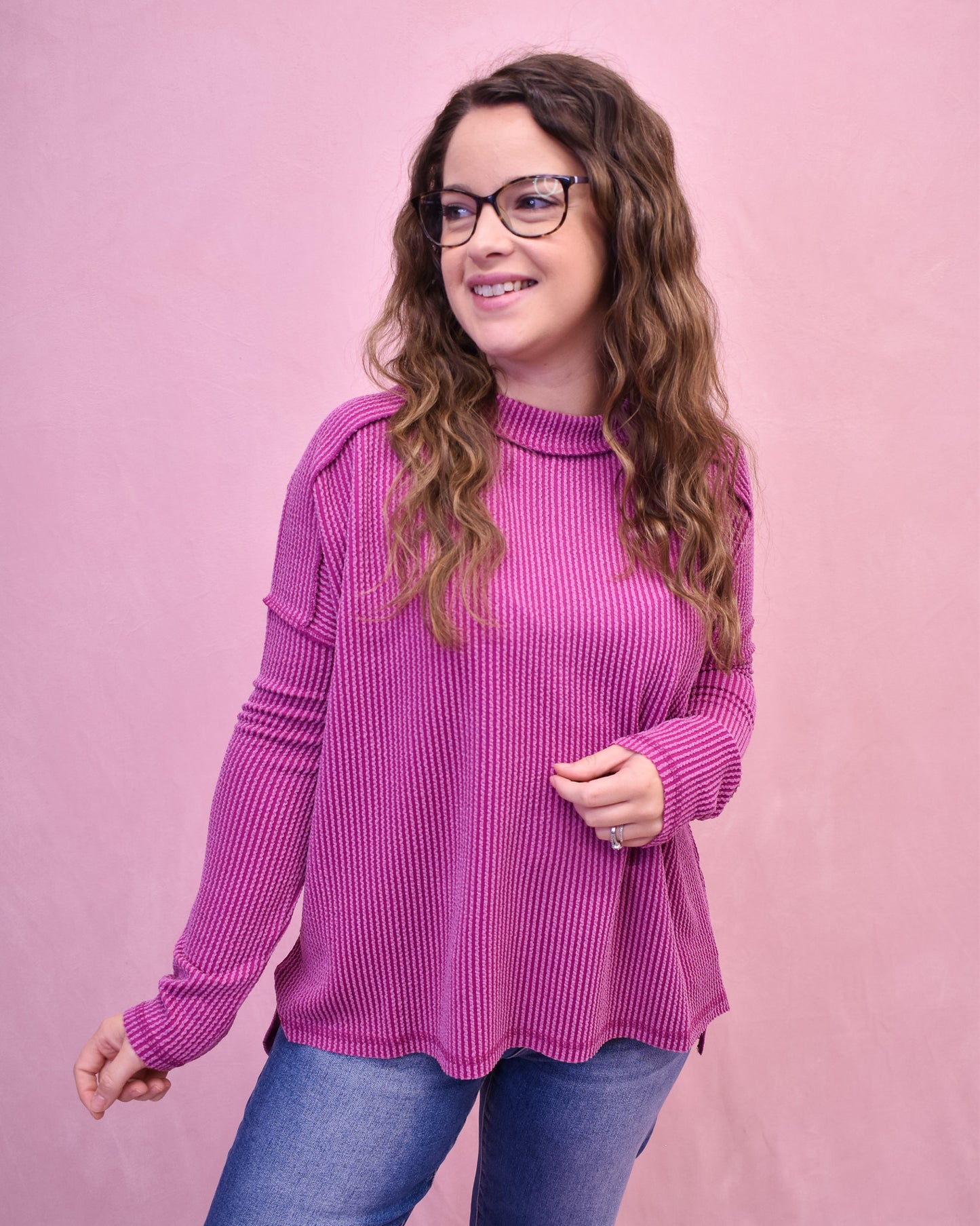 Woman wearing a pink sweater against a pink background
