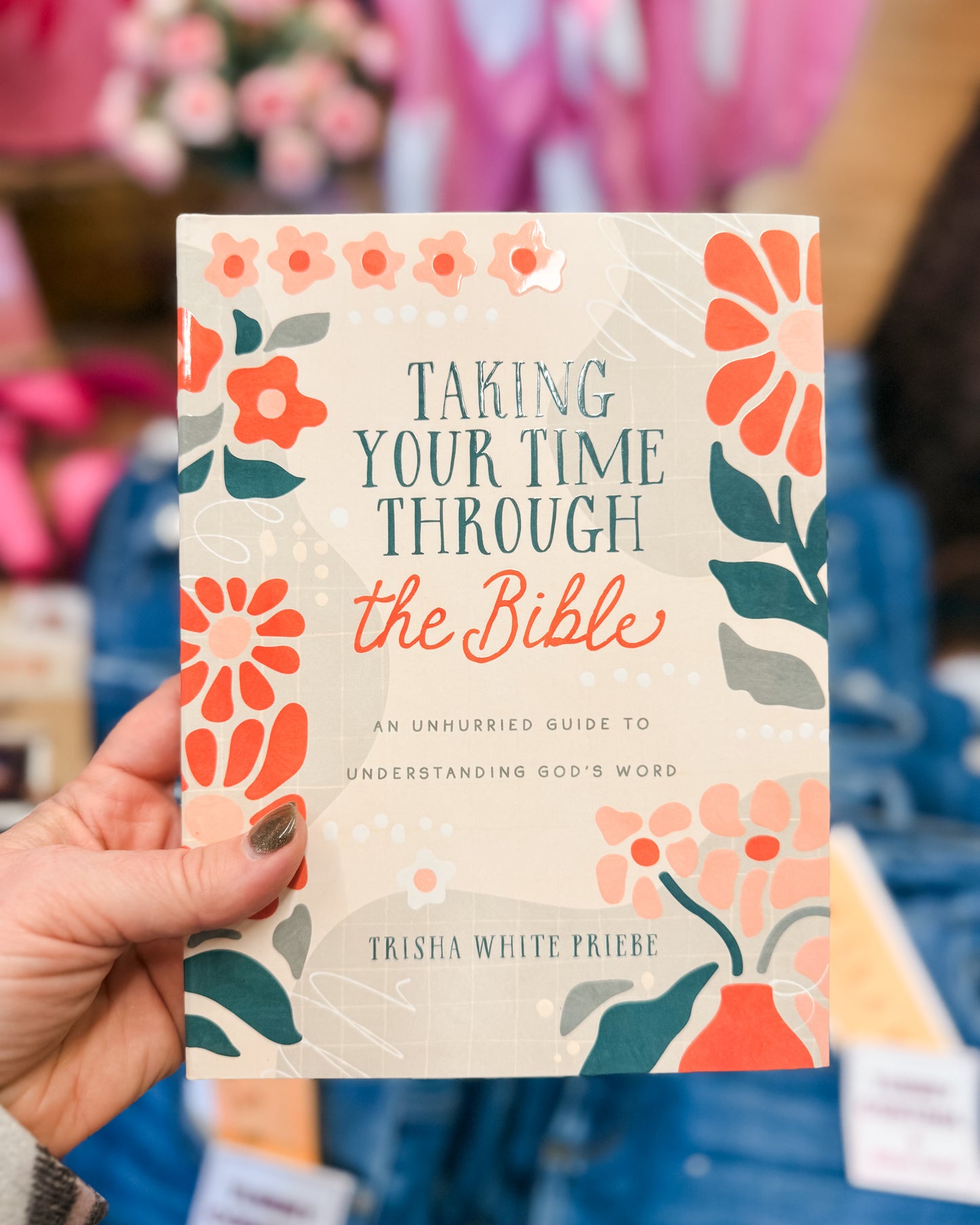 Book titled 'Taking Your Time Through the Bible' held by a hand with a floral design on the cover.