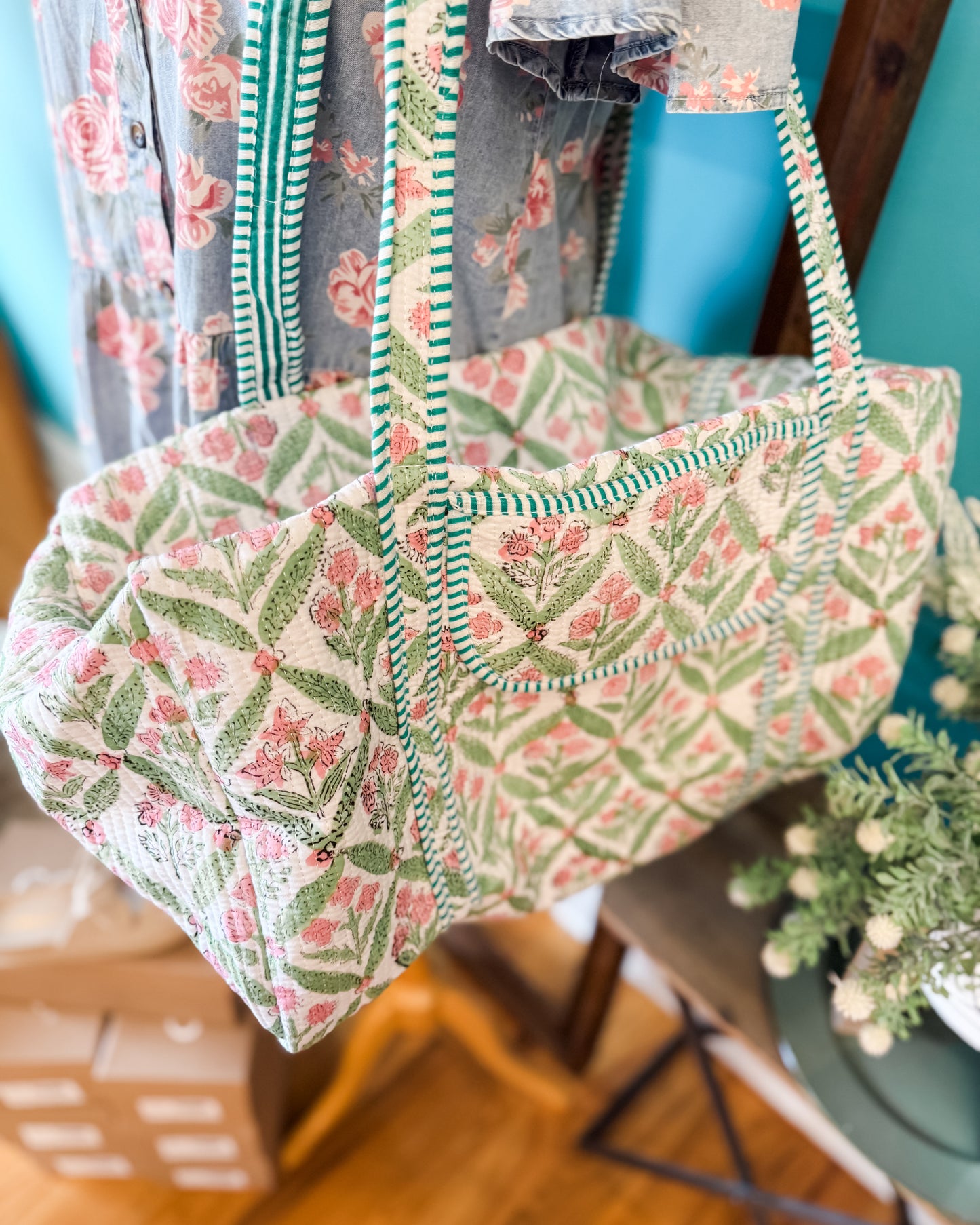 Floral patterned bag hanging on a chair with a blurred background