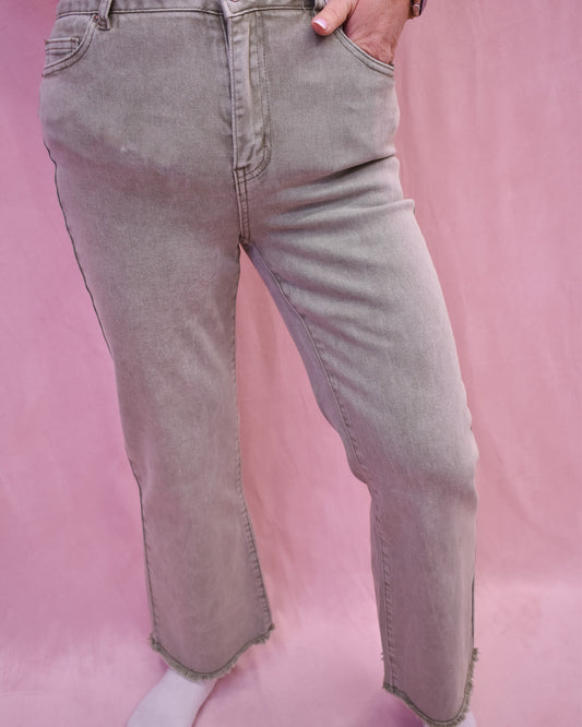 raw hem fitted denim jeans in a light olive color