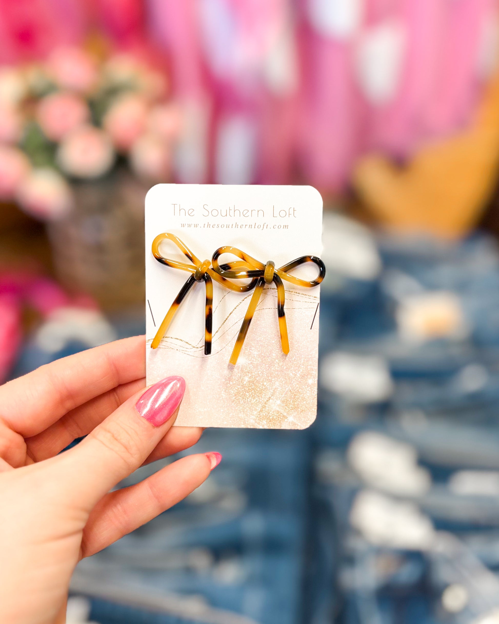 Card with a bow design held by a hand against a blurred background
