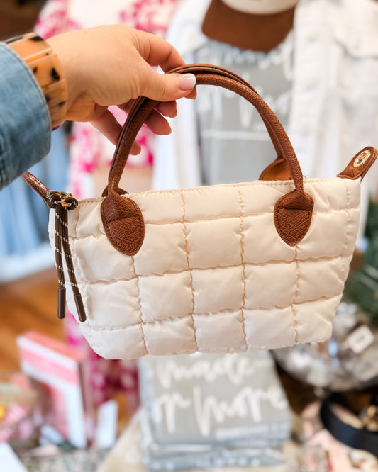 a small puffer handbag in cream with brown leather handles