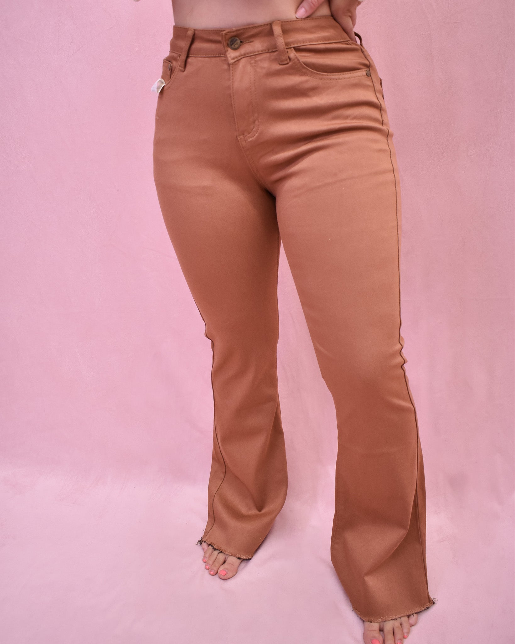 Tan pants worn by a person on a pink background