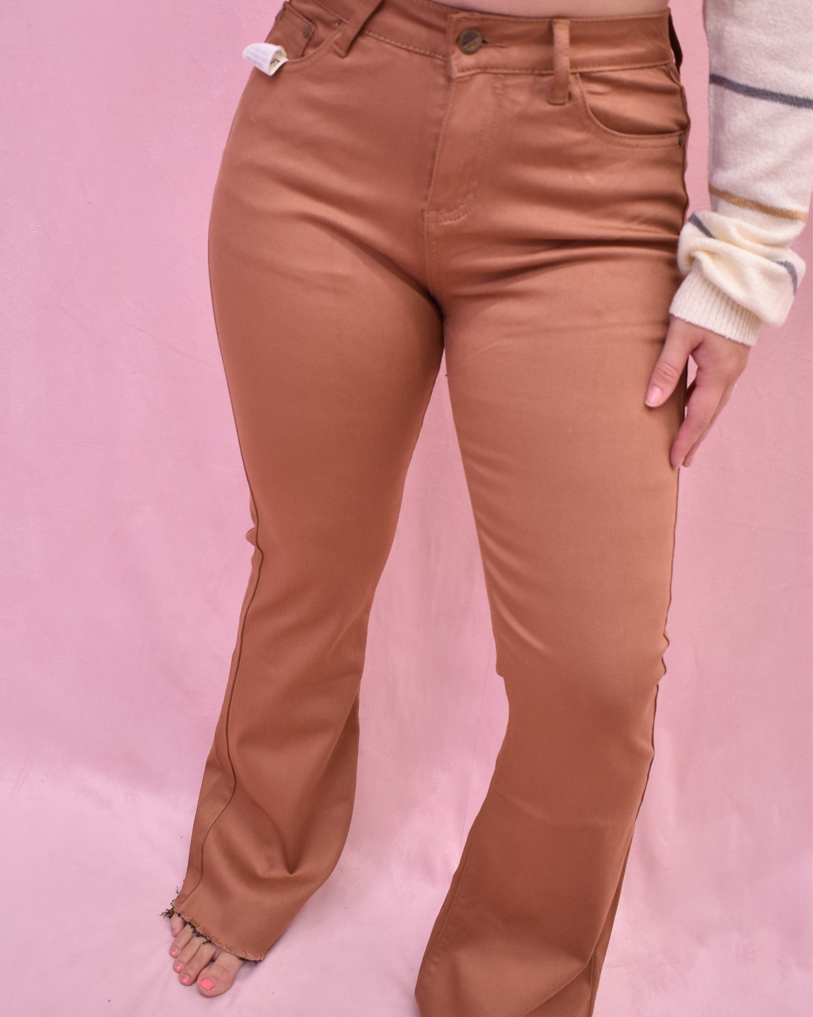 Brown pants worn by a person on a pink background