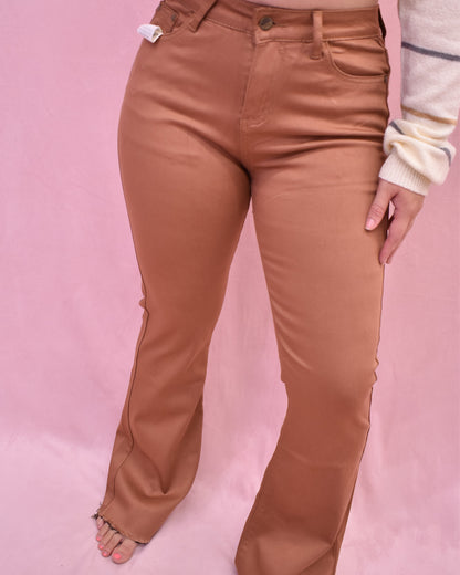 Brown pants worn by a person on a pink background