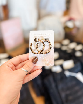 acrylic hoop style earrings in the color cream with brown dots to give it a tortoise look