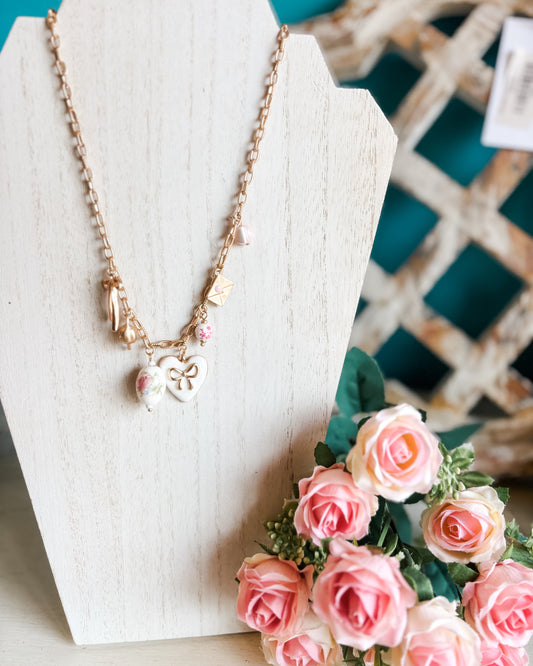 a chain link porcelain charm necklace with pink details