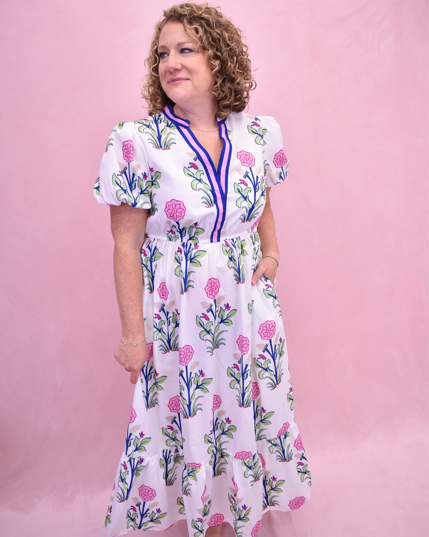 Woman wearing a floral dress against a pink background