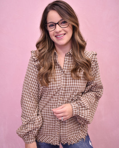 Woman wearing a checkered shirt against a pink background