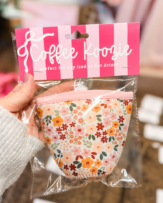 Floral coffee koosie in packaging with pink and white striped label