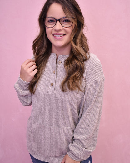 Woman wearing a light purple long-sleeve shirt against a pink background