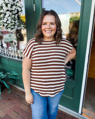 a short sleeve textured round neck and round hem top with cuffed sleeves and brown and cream stripes.