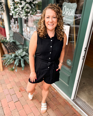 A sleeveless short romper with button down and waist tie
