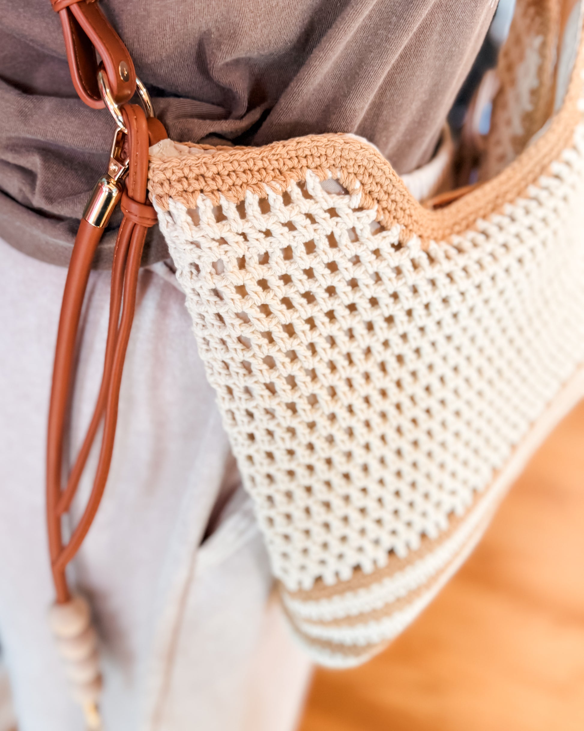Close-up of a woven crochet crossbody handbag with a leather strap