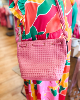 a woven bucket style purse in hot pink
