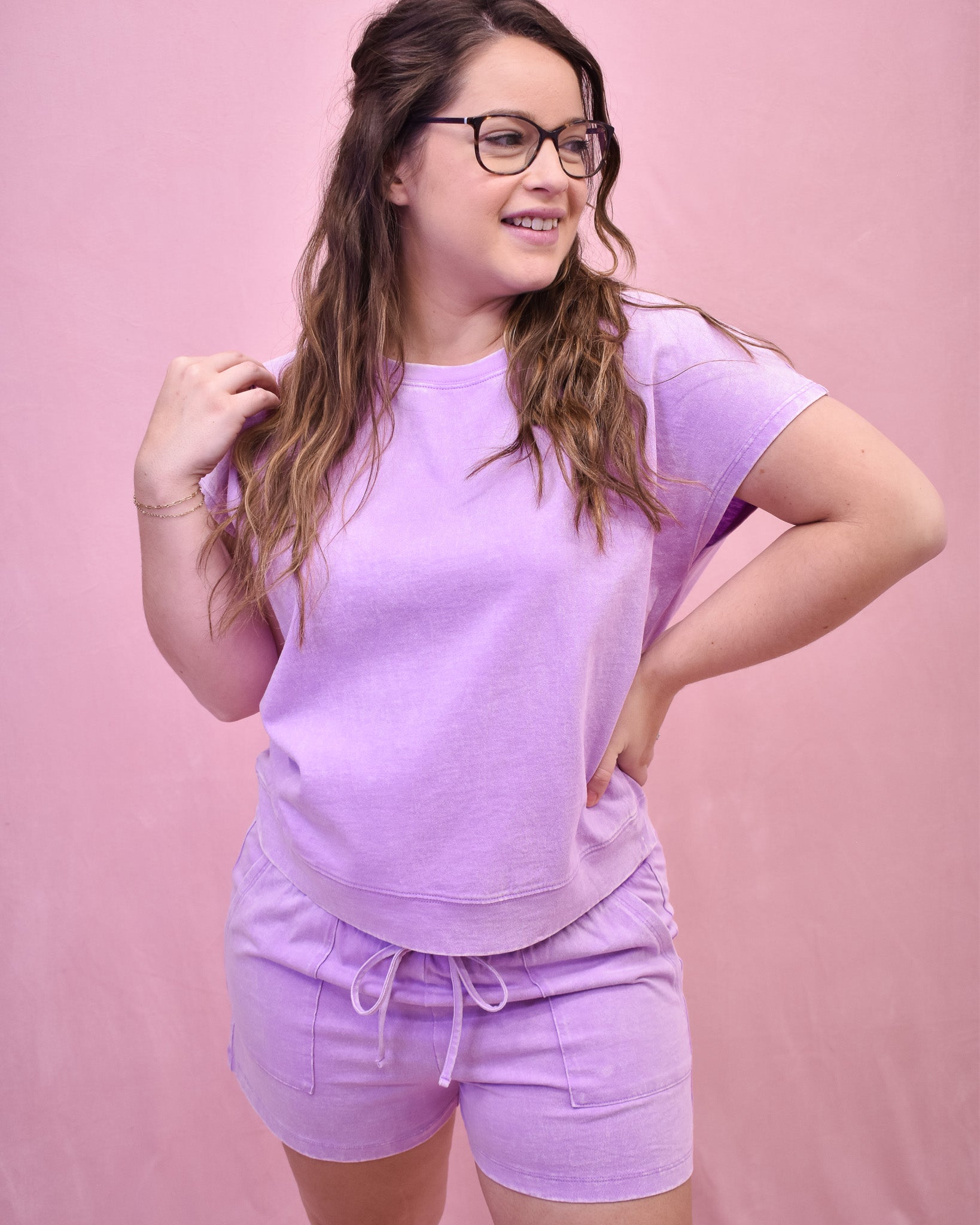 Woman wearing a light purple outfit against a pink background