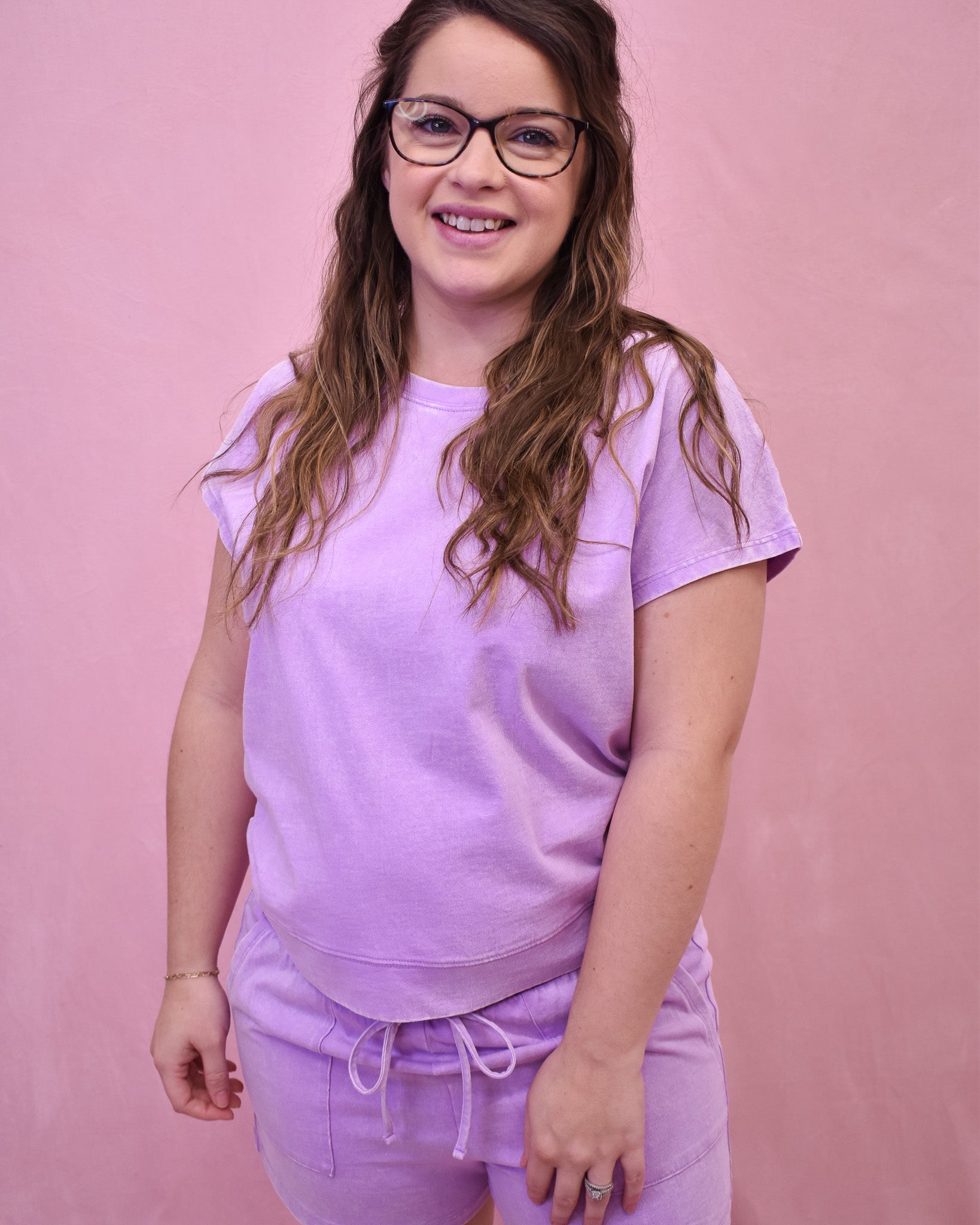 Woman wearing a purple outfit against a pink background