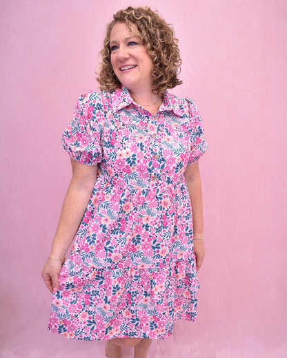 Woman wearing a floral dress against a pink background