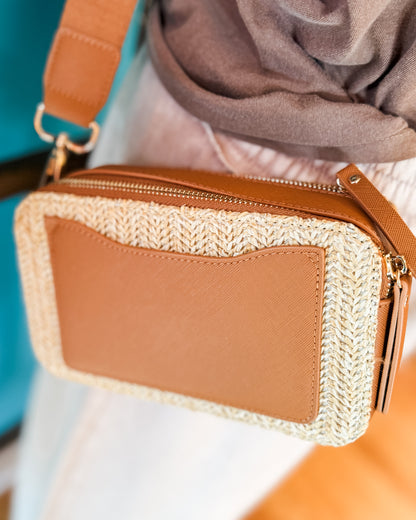 Brown handbag with woven detail with a crossbody strap and outside pocket