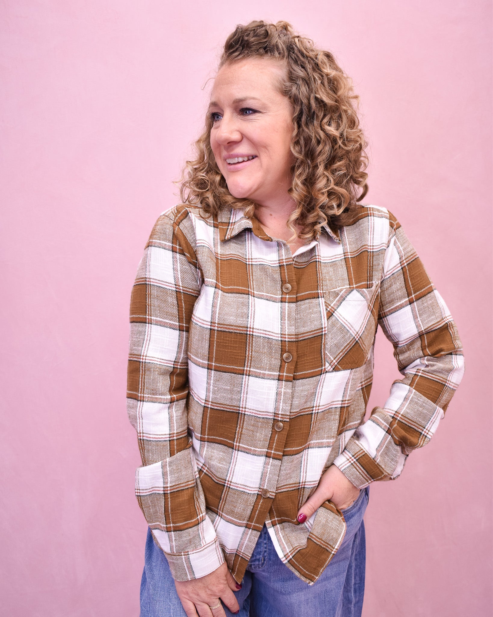 Woman wearing a plaid shirt against a pink background