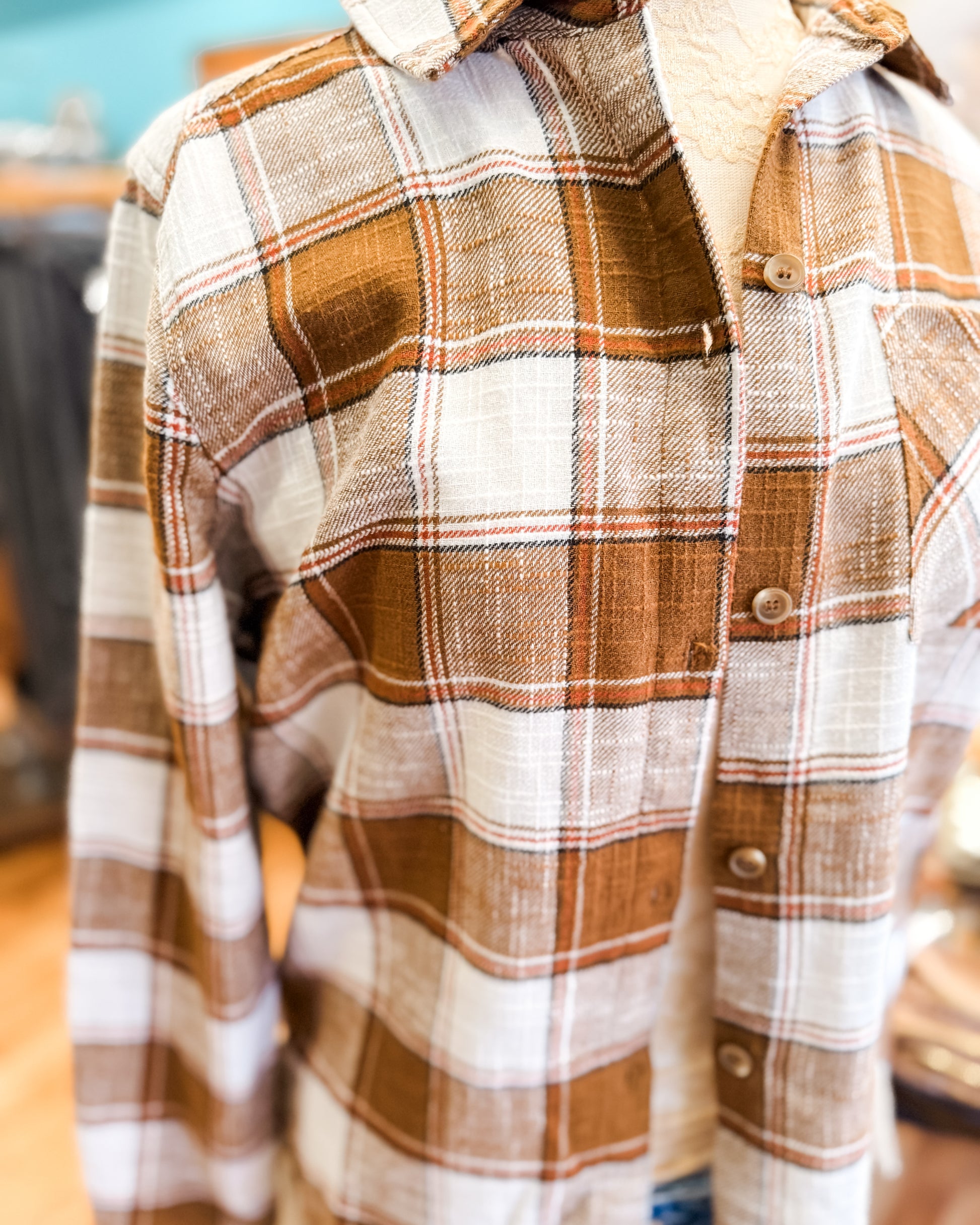Plaid shirt with brown and white pattern on a blurred background