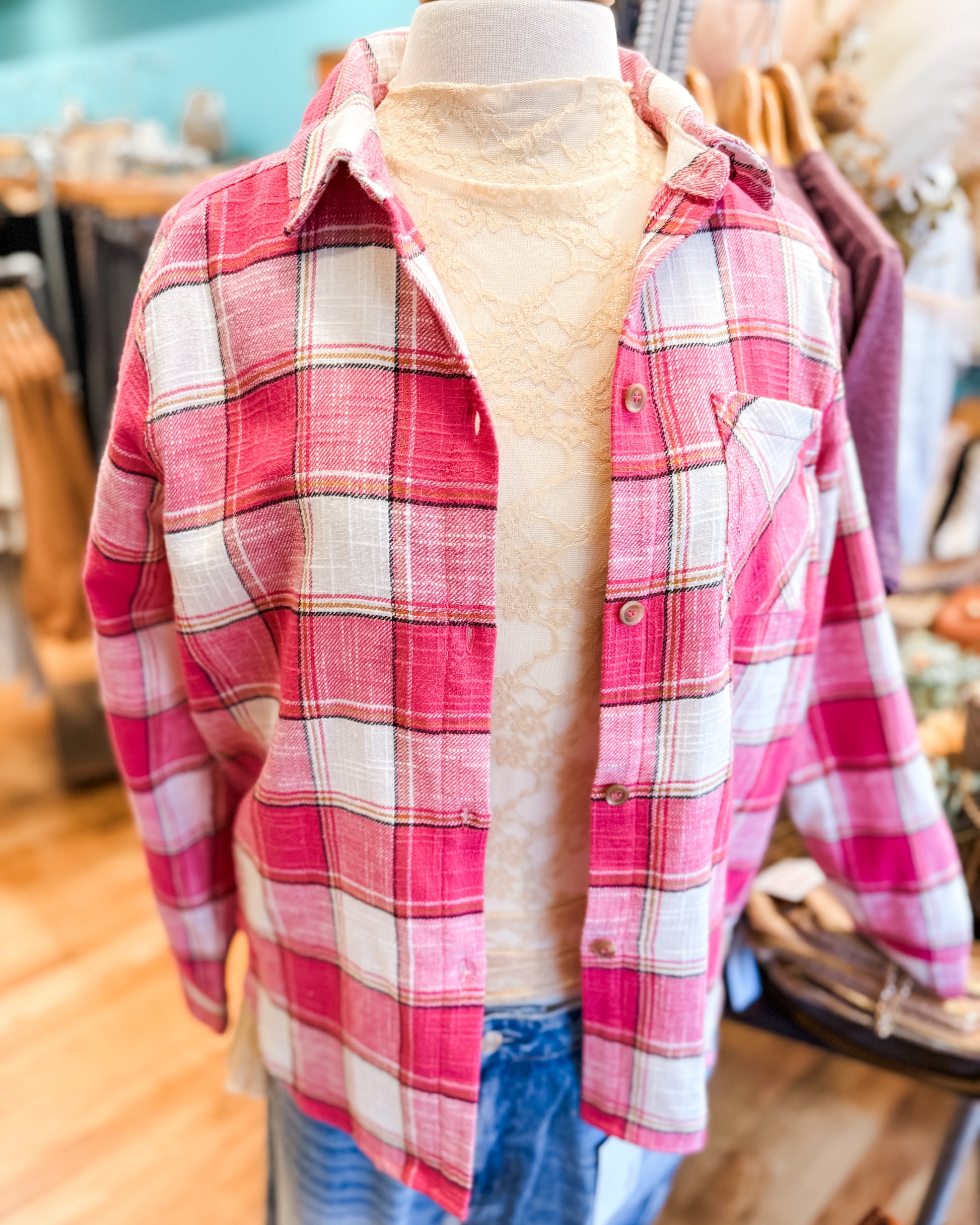 Mannequin wearing a red and white plaid shirt with a blurred indoor background