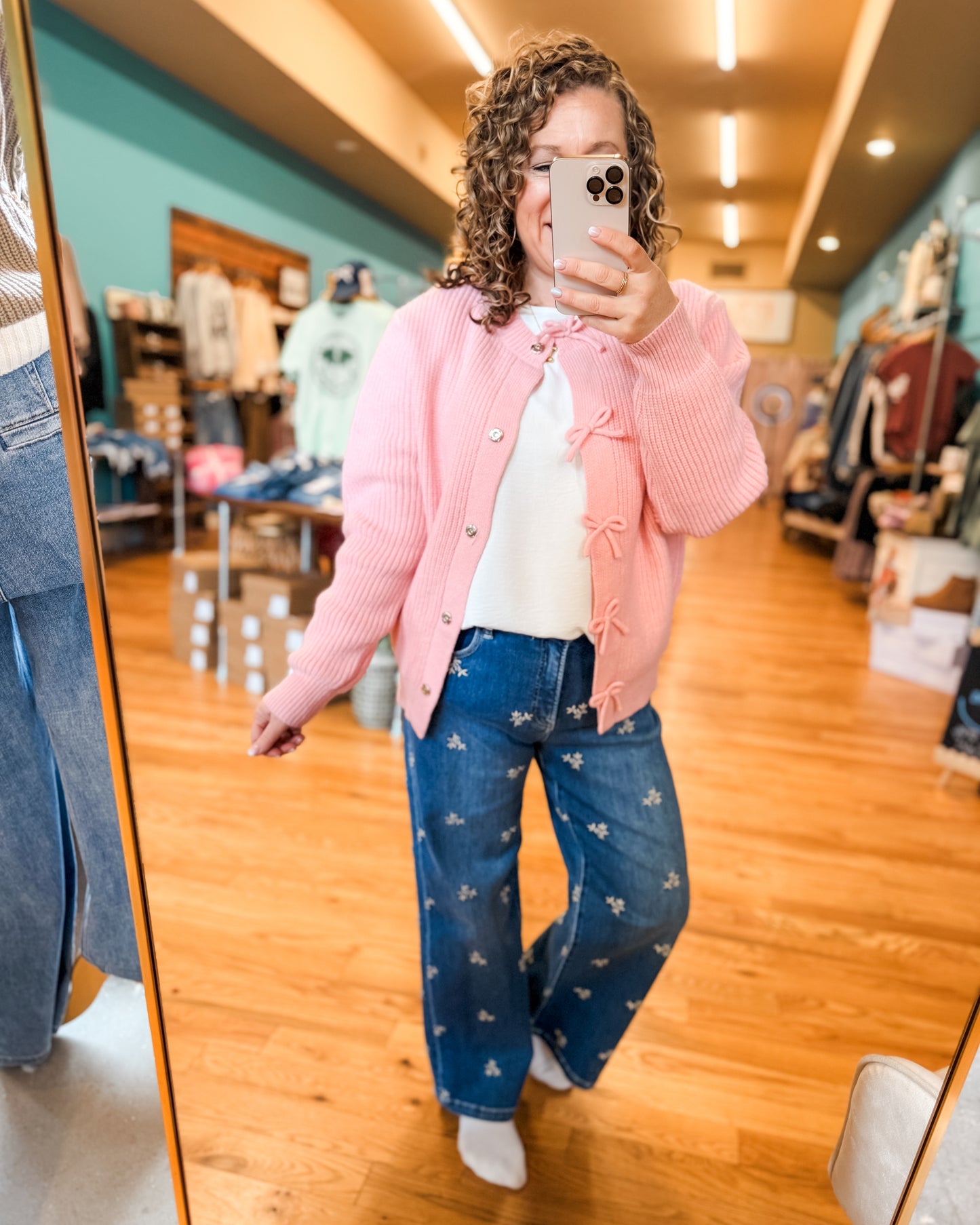 Pink bow cardigan paired with lightweight white basic top and embroidered floral jeans