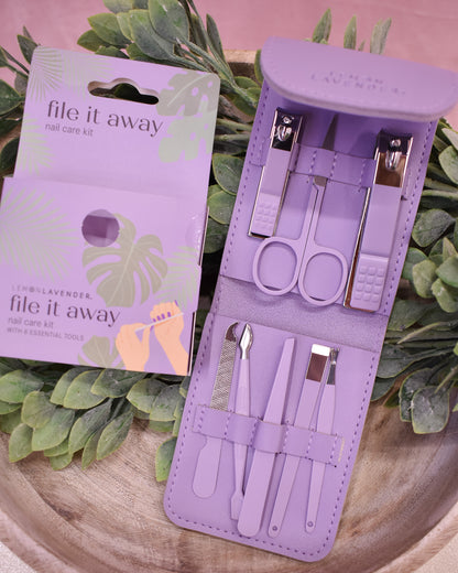 Purple nail care kit with tools and packaging on a green leafy background