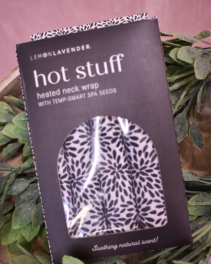Packaged heated neck wrap with floral pattern on a pink background