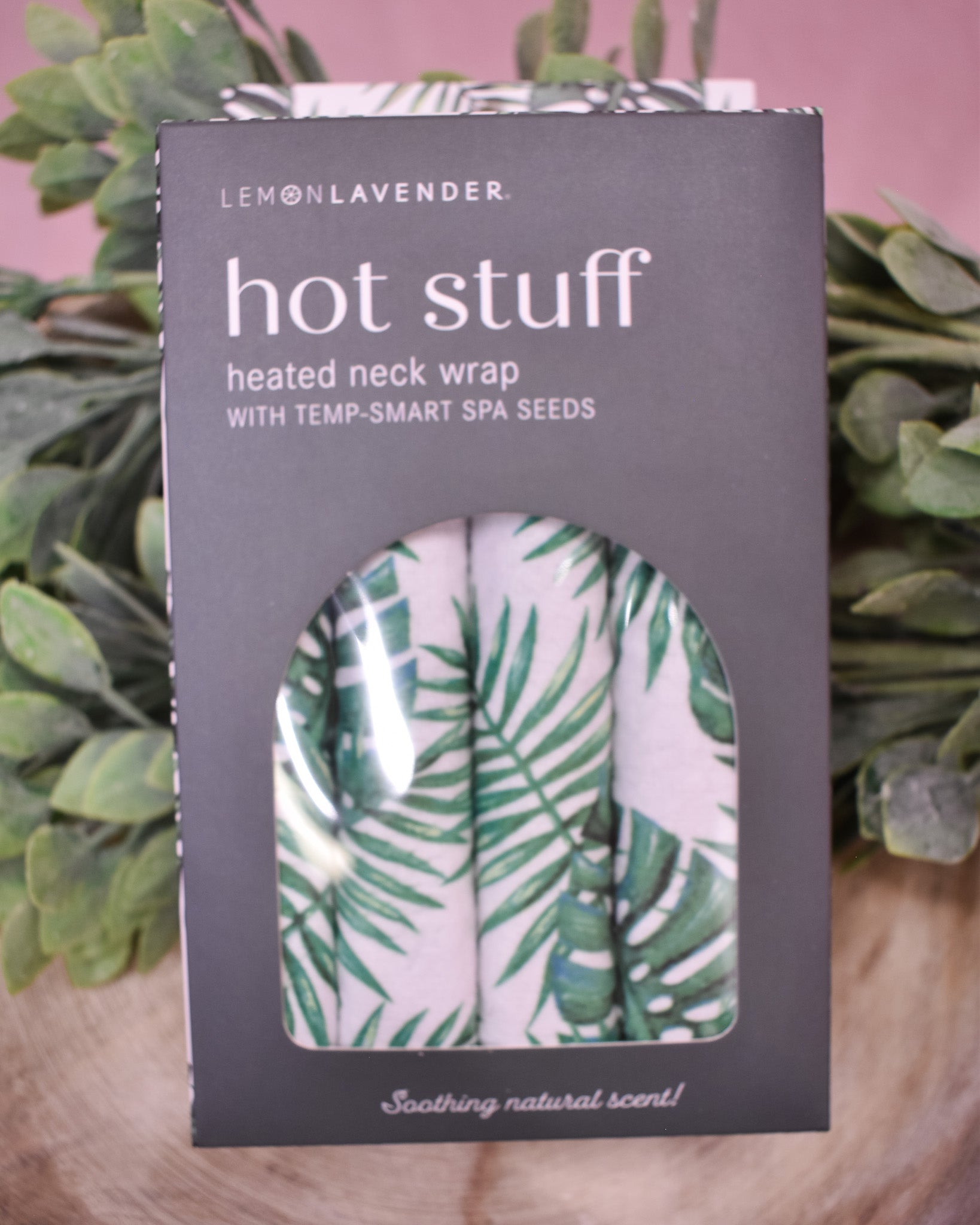 Lemon Lavender heated neck wrap packaging with palm leaf design on a wooden surface.