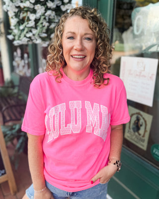 A graphic tee in neon pink with LULU MAC graphic in light pink and polka dots