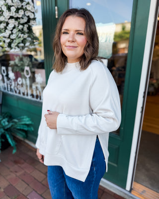 a long sleeve pullover in scuba soft material with a side slit