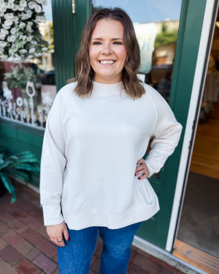 a long sleeve pullover in scuba soft material with a side slit