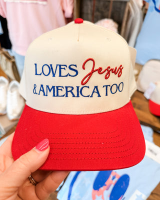 a canvas hat with red bill embroidered with loves Jesus and America too