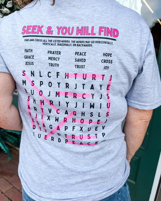a graphic tee with a seek and you will find bible verse crossword puzzle printed on the back