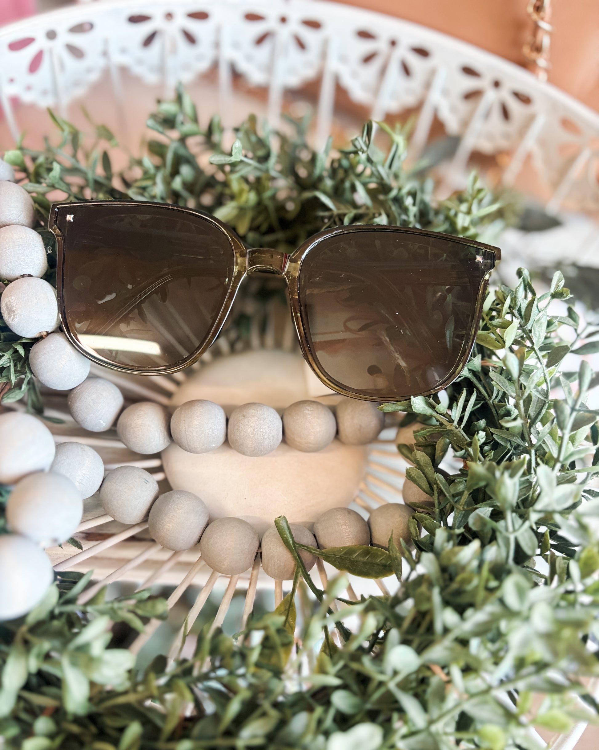 Sunglasses on a decorative wreath with beads and greenery