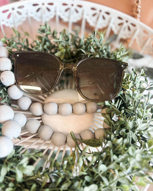 Sunglasses on a decorative wreath with beads and greenery