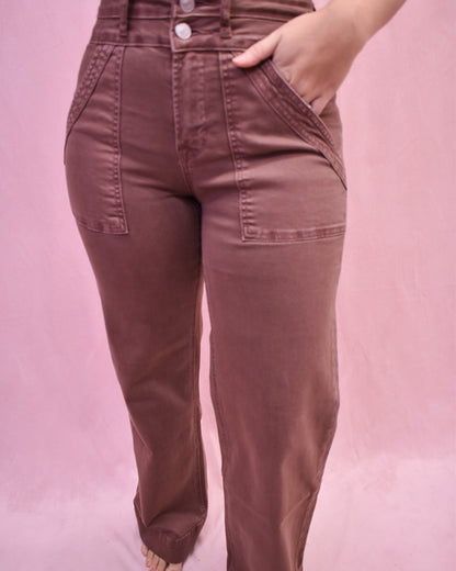 Brown pants worn by a person on a pink background