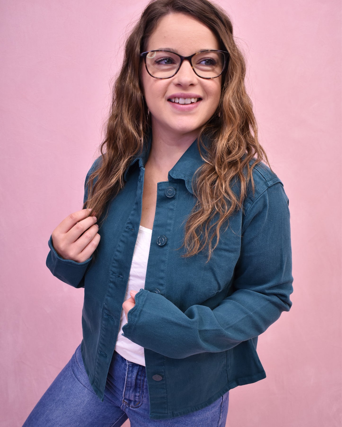 Woman wearing a blue jacket against a pink background
