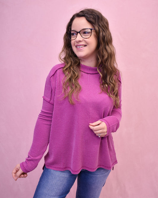 Woman wearing a pink sweater against a pink background