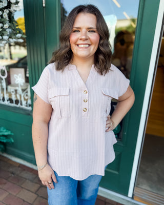a short sleeve half button down top in blush with silver pinstripes and a rounded hem