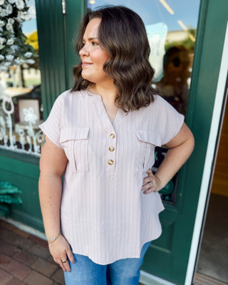 a short sleeve half button down top in blush with silver pinstripes and a rounded hem