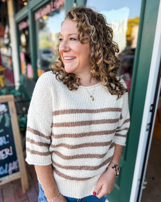 a cream mid length sleeve sweater with mocha stripes