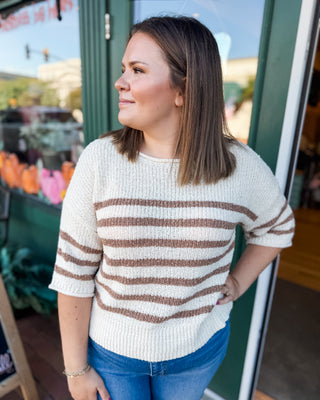 a cream mid length sleeve sweater with mocha stripes
