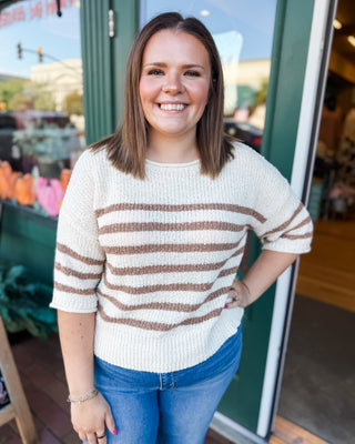 a cream mid length sleeve sweater with mocha stripes