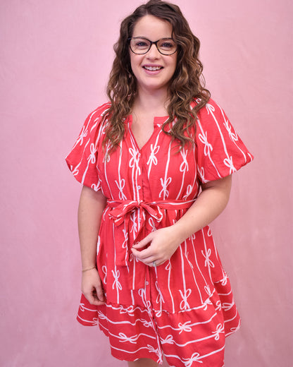 Puff sleeve hot pink dress with buttons down the front and a tie at the waist and bow detail design.