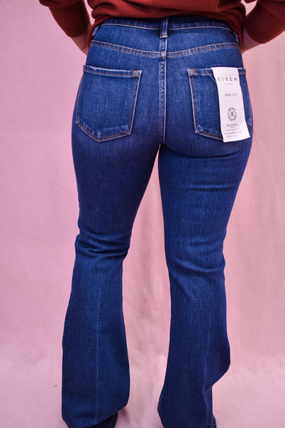 Blue jeans with a visible brand label on a pink background